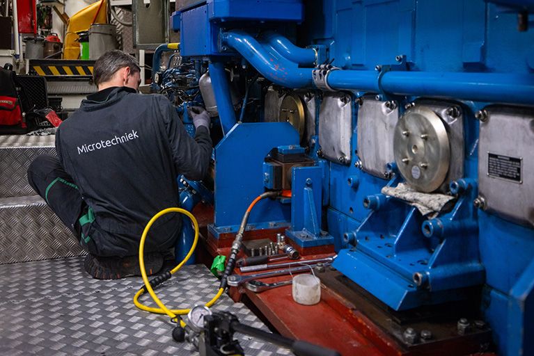 Monteur van Microtechniek voert service en onderhoud uit aan industriële machine voor technische installaties en machinebouw