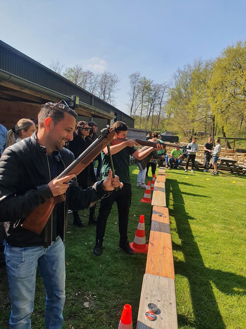 Medewerkers van Microtechniek doen mee aan een schietactiviteit tijdens bedrijfsuitje en teambuilding voor het team in precisietechniek en machinebouw