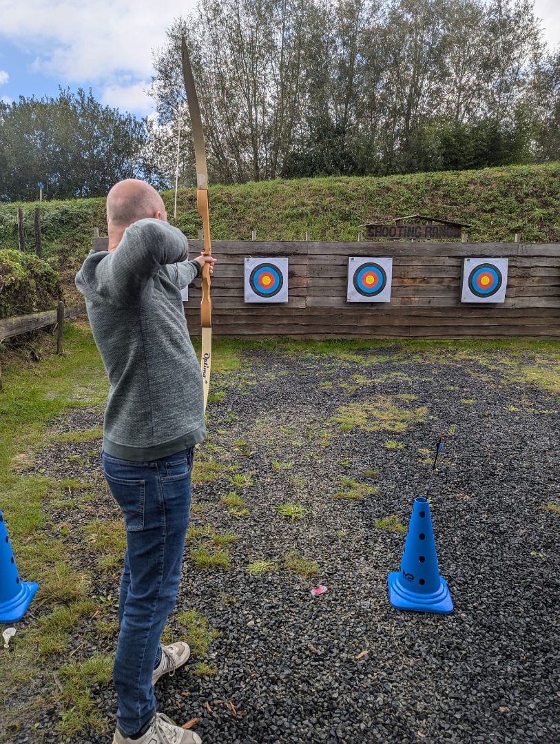 Medewerker van Microtechniek doet boogschieten tijdens bedrijfsuitje en teambuilding voor het team in precisietechniek en machinebouw
